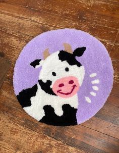 a rug with a cow on it is sitting on the floor in front of a wooden floor