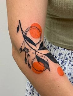 a woman with an orange and black tattoo on her arm