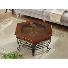 a coffee table with a glass top on a rug in front of a white couch