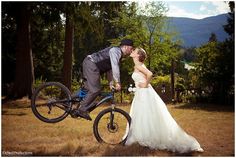 a bride and groom kissing on their bikes