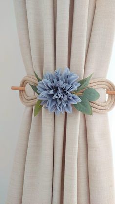 a blue flower sitting on top of a curtain