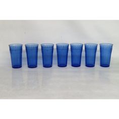 six blue glasses are lined up in a row