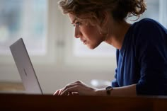 a woman sitting in front of a laptop computer