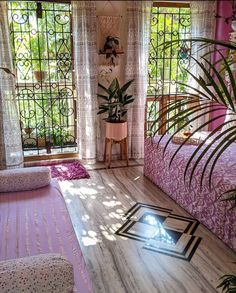 a bed room with a neatly made bed and lots of plants on the windowsill