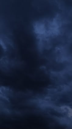 an airplane is flying in the dark cloudy sky