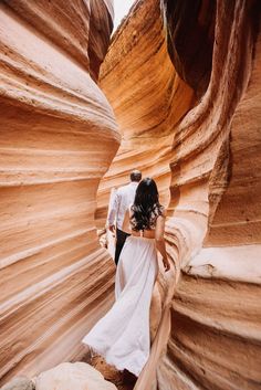 a bride and groom are walking through the slot in antelope canyon, arizona