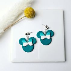 a pair of mickey mouse earrings on a white plate