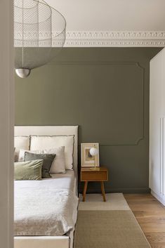 a bedroom with green walls and white bedding