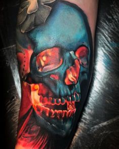 a man's arm with a colorful skull and flower on the left side of his arm