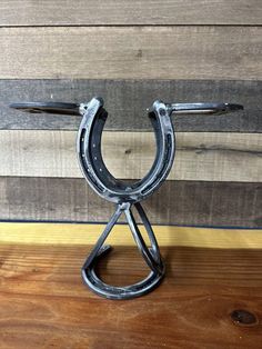 a horseshoe shaped metal object sitting on top of a wooden table