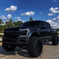 a large black truck parked on top of a parking lot