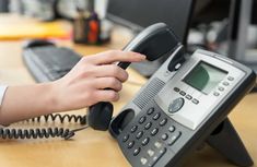 a person is using an old style phone to call someone on their computer or telephone