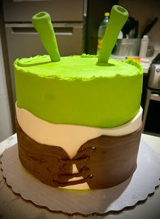 a cake with green frosting and two wooden sticks sticking out of it's top