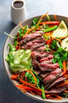 a bowl filled with meat and veggies on top of a table