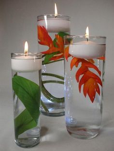 three glass vases with candles in them