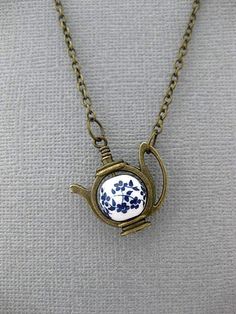 Forget Me Not Teapot Necklace OVERVIEW: This Necklace can be used with a lot of different themes in mind. If you are leaning towards a fairytale vibe, like Alice In Wonderland, then yes this will work for you. It also provides a simply charming vibe. And it is great for Tea Lovers. If you just love flowers, maybe Blue flowers, then maybe you'll fancy this necklace for that reason. But our absolute favorite way to think of this necklace, is of course, with the Forget Me Not theme in mind. Forget Whimsical Blue Necklace For Gifts, Forget Me Not Accessories, Alice In Wonderland Necklace, Forget Me Not Flower Jewelry, Alice In Wonderland Jewelry, Forget Me Not Pendant, Dragons Breath Fire Opal, Teapot Necklace, Pressed Flower Jewelry