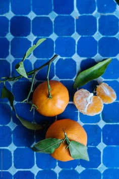 three oranges on a blue and white tile table