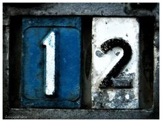 the number two is written in black and white on an old metal plate with blue paint