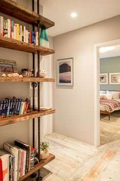 a book shelf filled with lots of books next to a door way in a room