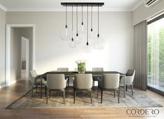 a dining room table with chairs and lights hanging from the ceiling