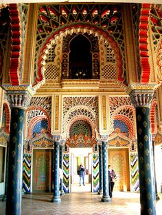 an elaborately decorated building with columns and arches in front of the entrance to it