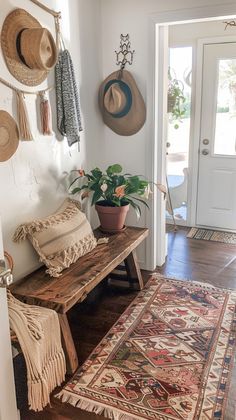 a wooden bench sitting on top of a hard wood floor next to a rug and hat rack