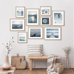 a white room with pictures on the wall and a wooden bench in front of it