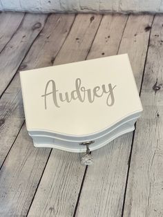 a white box with the word audrey on it sitting on a wooden floor