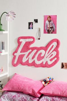 a bedroom with pink bedding and pictures on the wall above it that says fack