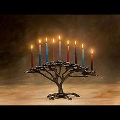 a happy hanukkah menorah card with lit candles on a table