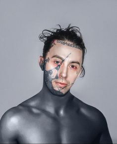 a man with black paint on his face and chest is looking at the camera while posing for a photo