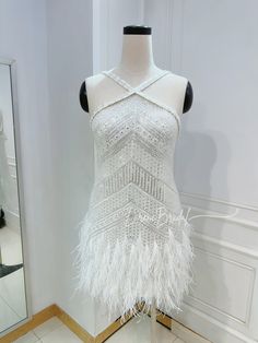 a mannequin with white feathers on it in front of a mirror and door