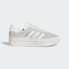 It wouldn't be a list of adidas' most iconic shoes without the Gazelle. First worn on indoor courts in the '70s, the suede shoe is gaining new fans to this day. Now the style you covet is lifted up to new heights. It's stacked three layers high, for a new perspective on the classic style. The details stay sporty with buttery-soft suede and serrated 3-Stripes. A metallic-gold "Gazelle" is the final stamp of our heritage. Cutest Shoes For Teens, Casual Shoes For Women Sneakers, Shoes To Ask For For Christmas, Women’s Adidas Sneakers, Cute Dressy Shoes, Adidas Shoes Women Platform, Trendy Everyday Shoes, Gray Adidas Shoes Outfit