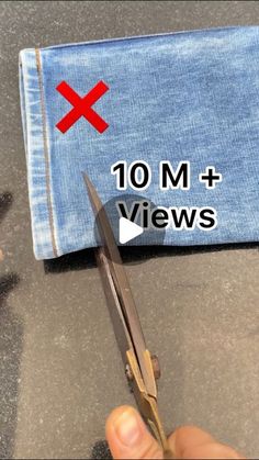 a pair of scissors being used to cut jeans