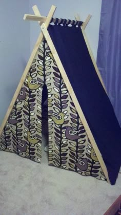 a teepee tent made out of wood and fabric with an animal design on it