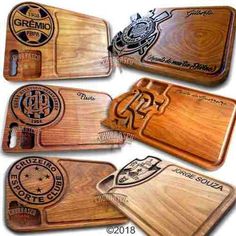 four wooden cutting boards with engraved logos on them, one has a knife and the other is