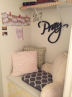 a room with a chair and some pillows on the shelf next to bookshelves