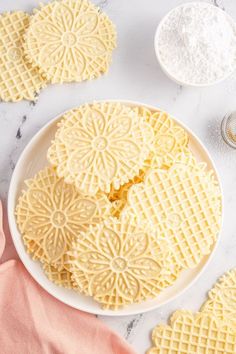 some waffles are on a white plate and next to other ingredients for making cookies