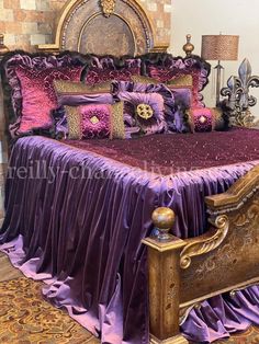 a bed with purple bedspread and pillows on it