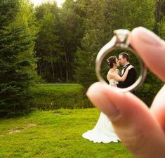 a person holding a ring in front of their face with the image of a bride and groom