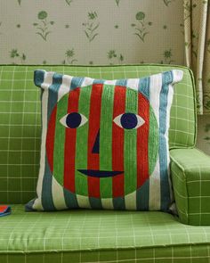 a green couch with a colorful pillow on it