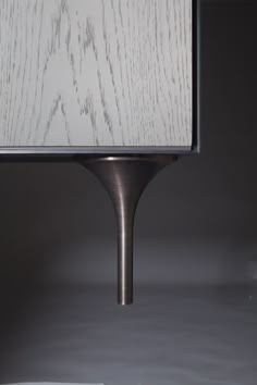 a lamp that is sitting on top of a table next to a white cloth shade