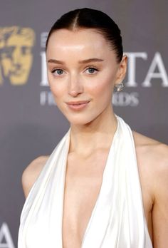 a woman in a white dress posing for the camera