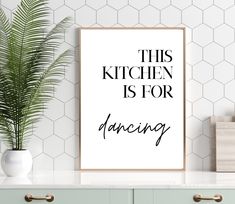 this kitchen is for dancing poster hanging on the wall next to a potted plant