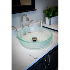 a glass bowl sink sitting on top of a white counter