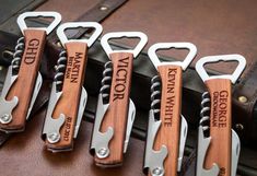 six wooden bottle openers with engraved names on them are lined up in a row