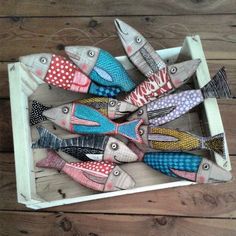 a box filled with small colorful fish on top of a wooden floor