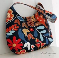 a handbag hanging up against a wall with a flower design on the front and side