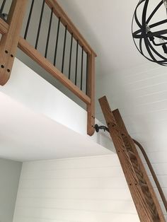 a wooden stair case next to a light fixture