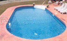 an empty swimming pool with lounge chairs around it